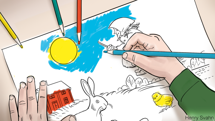 Hand som färglägger en bild på  påskkärring, hare, kyckling, sol och ett hus.
