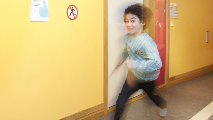 Bilden visar en pojke som springer snabbt i korridoren.