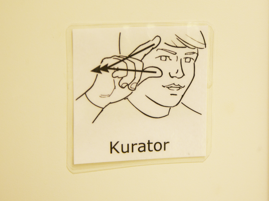 Bilden visar det ritade tecknet för ordet kurator
