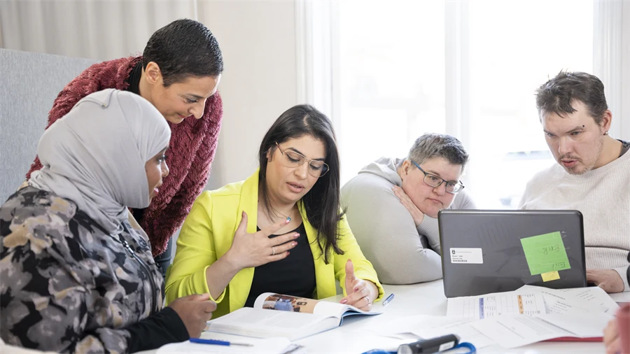 Bilden visar en grupp med människor som diskuterar med varandra.