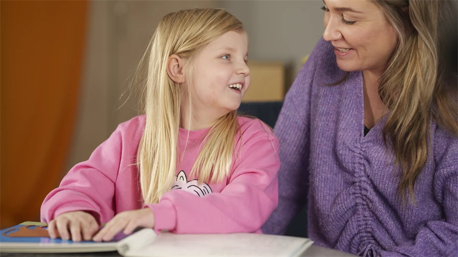 En elev och en lärare ler mot varandra