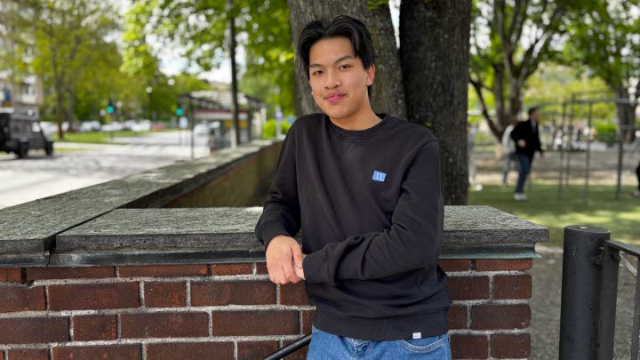 Sean står framför en tegelmur.