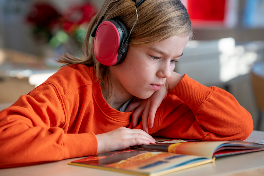 Elev läser och har hörselskydd 