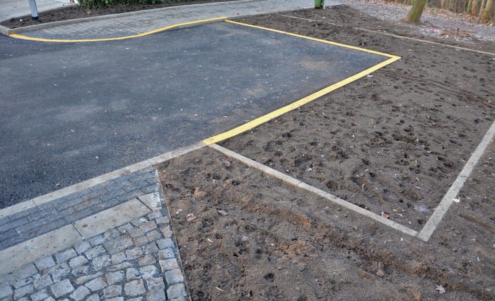 Fotografi som visar en asfaltsplan där ett gult streck är målat längs kanten mot jorden.