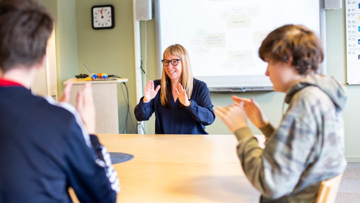 Bild på två elever som interagerar med en lärare.