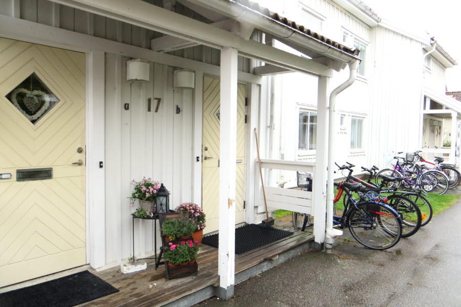 Framsidan av ett vitt hus med gul dörr.