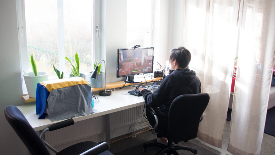 En person som sitter framför en dator vid ett skrivbord.