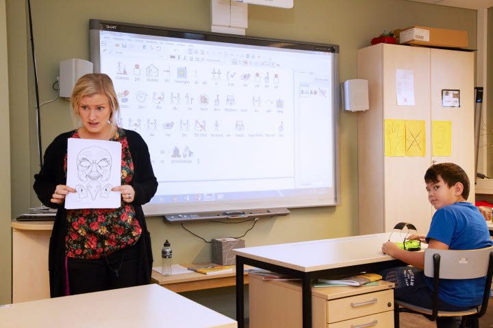 Bilden visar en lärare och en elev i ett klassrum