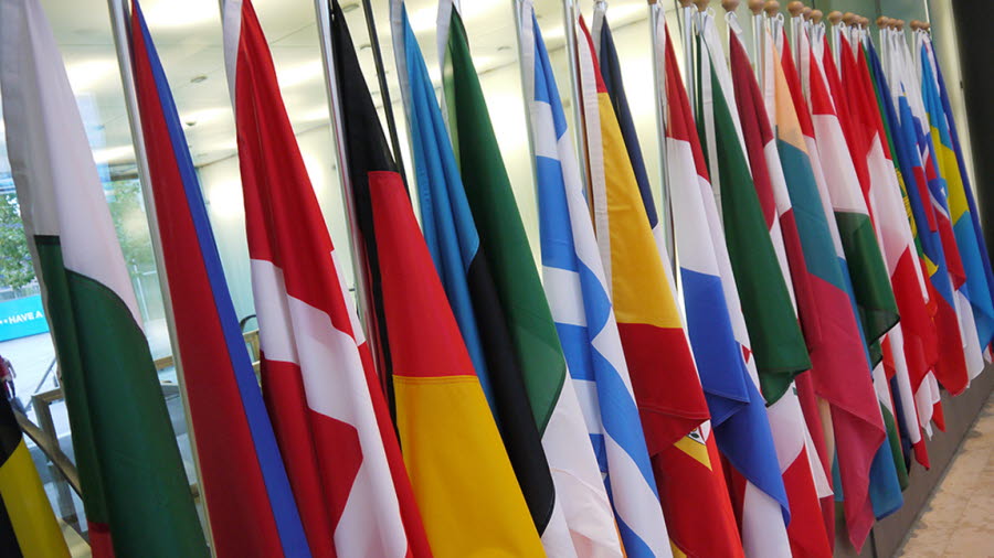 I ett rum står europeiska unionens medlemsflaggor på rad