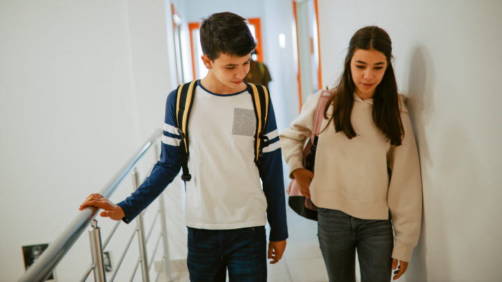 Två ungdomar går i korridoren tillsammans.
