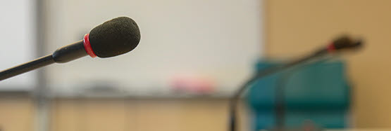 Bild på en mikrofon till hörhjälpmedel i ett mötesrum.