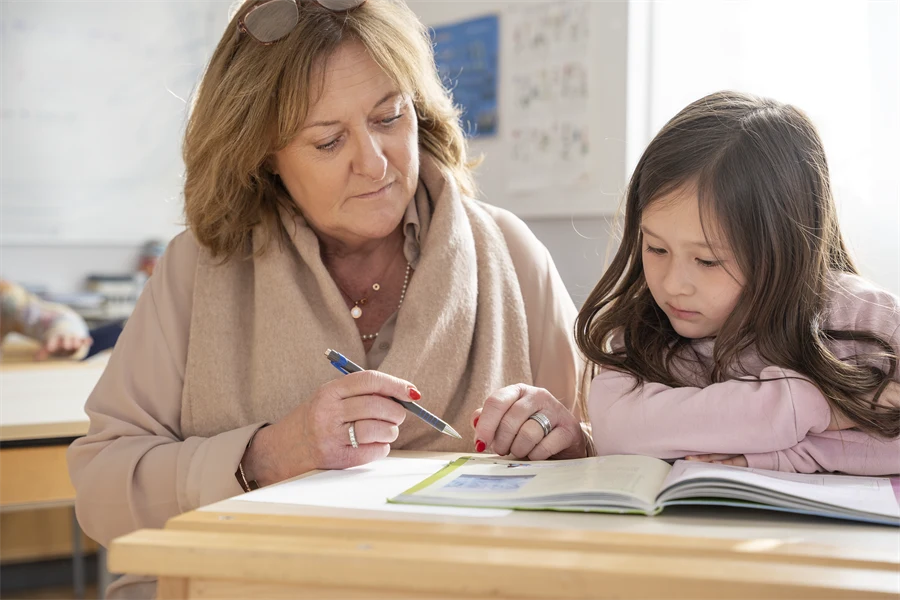 En lärare och en elev tittar i en bok