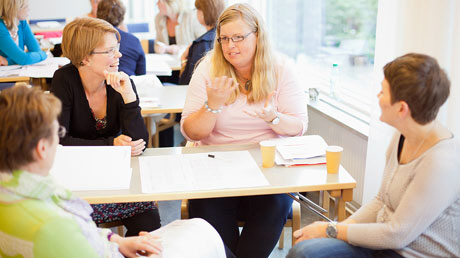 Vuxna diskuterar i grupp