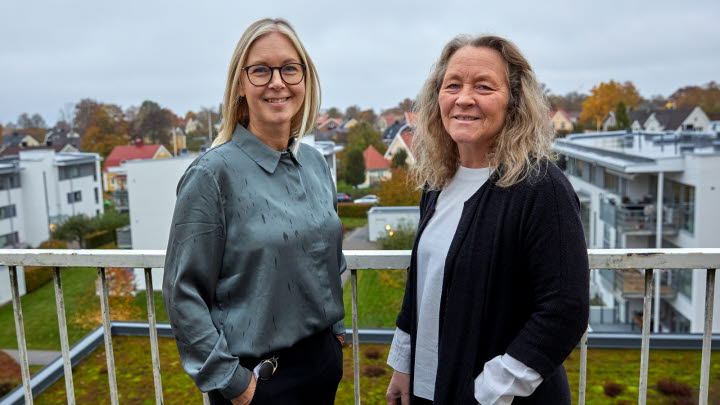 Bilden visar Malin Liljeqvist och Annika Sandberg stå bredvid varandra på en balkong och blir fotograferade. 