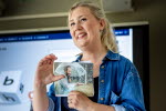 Läraren Sofie Svernhagen gör ett handtecken framför en bild.