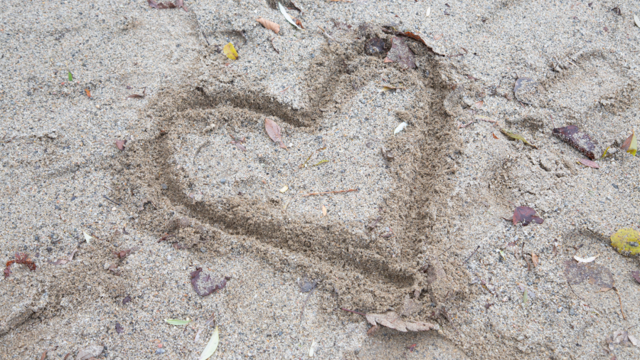 Ett hjärta ritat i sand.