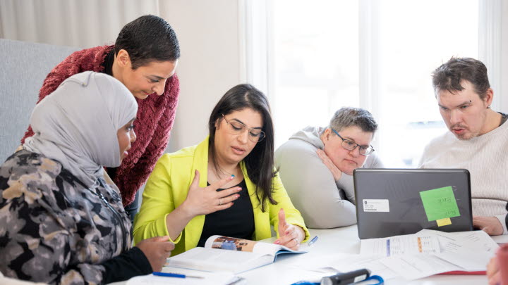 Bilden visar en grupp med människor som diskuterar med varandra.Bilden visar en grupp med människor som diskuterar med varandra.