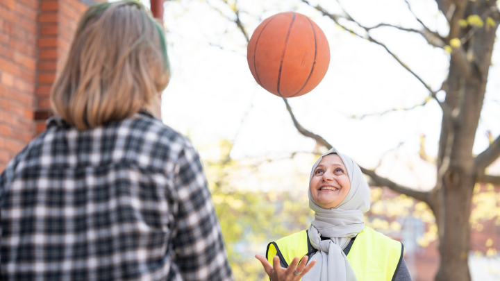 Lärare och elev bollar med en basketboll